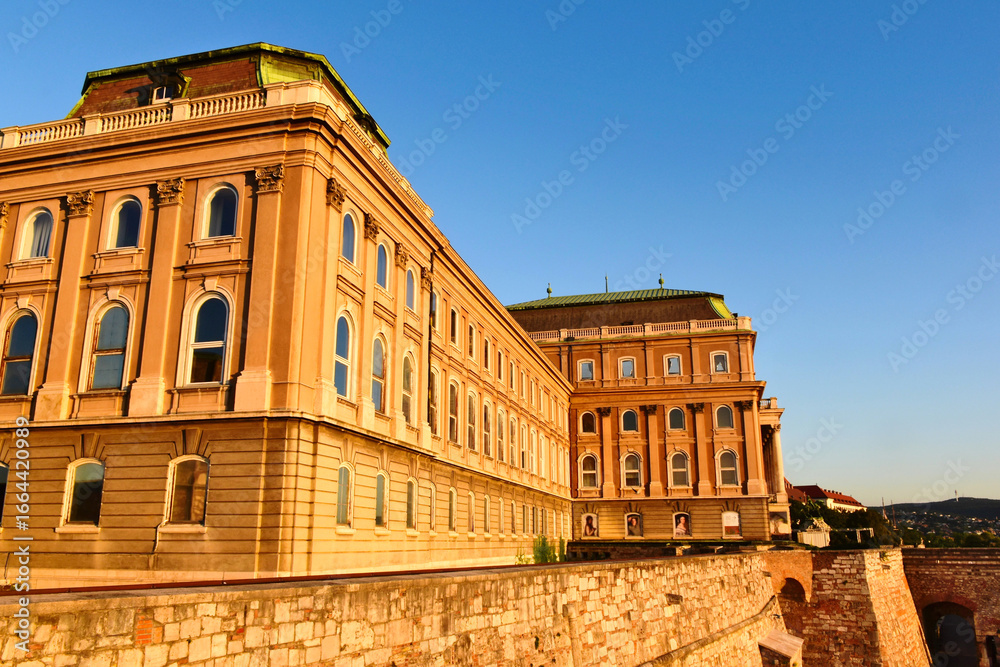 Obraz premium elevation perspective of the Buda castle in Budapest, Hungary at sunrise. historic landmark building on the Buda hill by the Danube housing the Art Gallery. popular tourist attraction. travel concept