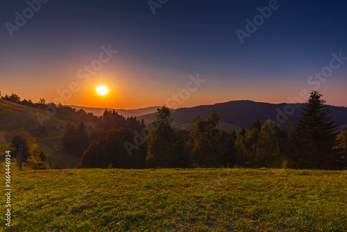 Fototapeta Naklejka Na Ścianę i Meble -  Górski krajobraz wśród wzgórz i bujnych zielonych pól, złota godzina, naturalne piękno, Beskidy, Cieńków, Polska