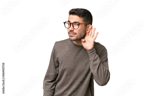 Canvastavla Young handsome caucasian man over isolated background listening to something by