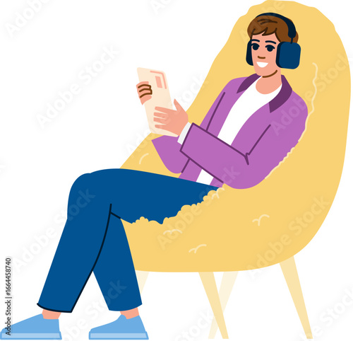 Young man relaxing on armchair listening to music and reading a book