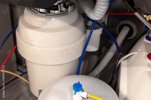 Fototapeta Close-up of a kitchen garbage disposal system installed under the sink, with con