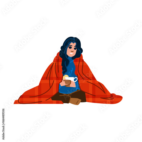 Woman wrapped in blanket enjoying hot drink and cookies
