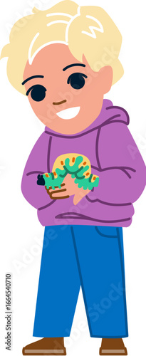 Blond boy holding a caterpillar smiling and looking down