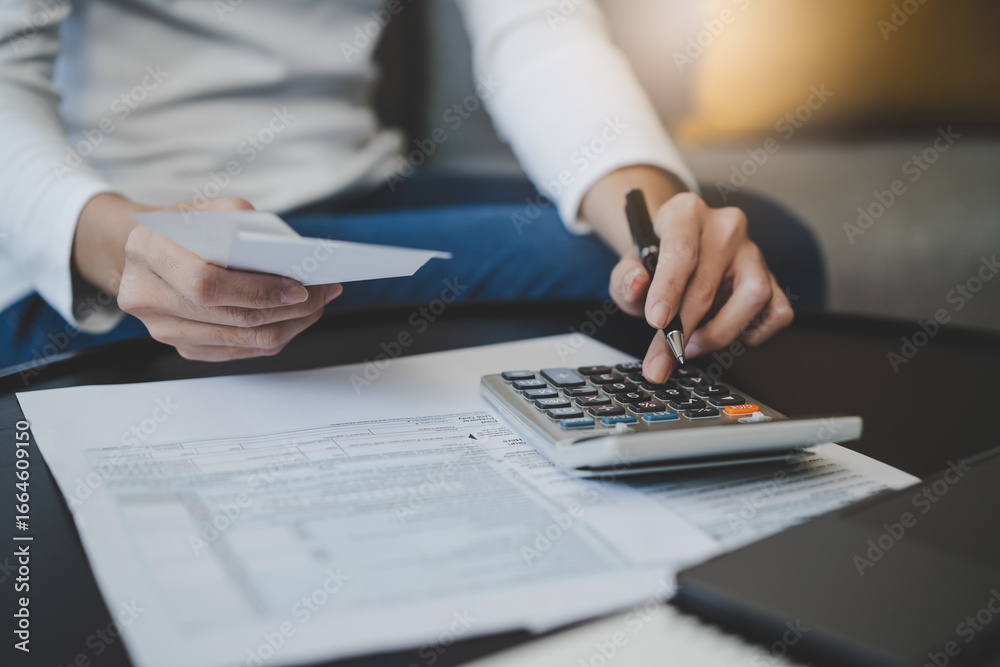 Fototapeta premium Women business people use calculators to calculate the company budget and income reports on the desk in the office.