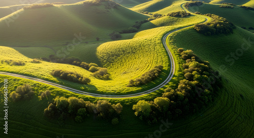 Jalan berkelok yang menakjubkan melewati bukit-bukit hijau yang cerah, bermandikan sinar matahari keemasan, sempurna untuk iklan perjalanan dan menginspirasi perjalanan indah masa kini!