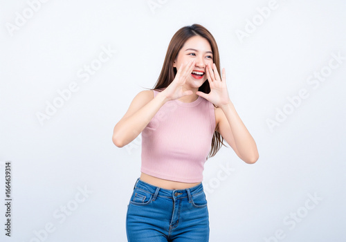 Excited Asian girl yelling a secret or shouting good news, isolated on white background.