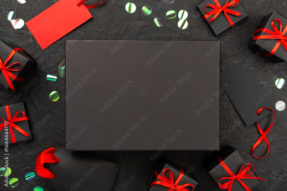 Obraz premium Mock up space with black gift boxes on concrete background, top view. Black Friday concept