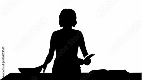 Silhouette of a woman standing at a table with a bowl and book in front of her in black and white tone