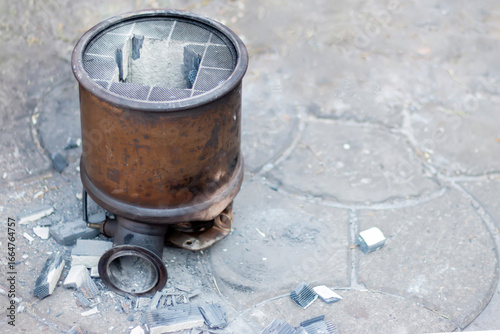 Close-up of a damaged truck's DPF, diesel particulate filter. The core of  catalytic converter is an internal ceramic honeycomb structure that has a coating containing precious metals.