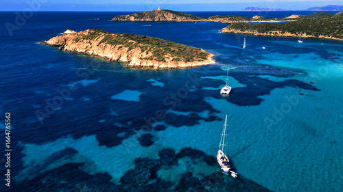 Tourist Boats Anchored near Rocky Coastline of Sardinia, Italy, Aerial Shot