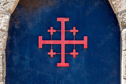 Close up of the Red Jerusalem Cross or Crusader Cross on the blue door of Saint John's Baptist Church in the old city of Acre, Akko Israel.
