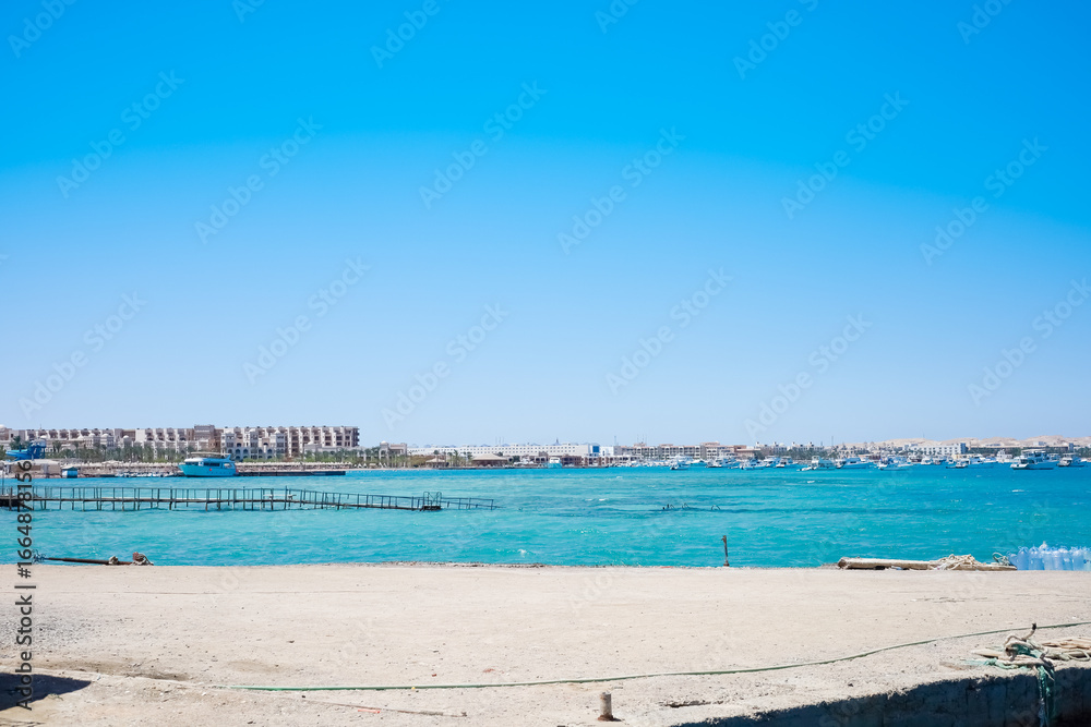 Fototapeta premium Coastal cityscape with boats and clear sky