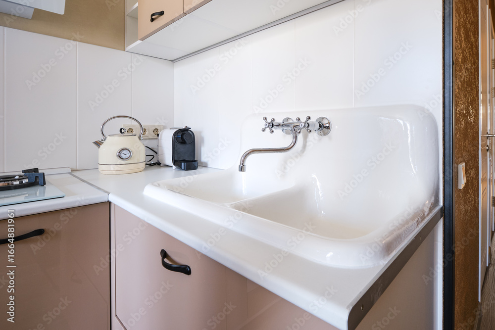 Fototapeta premium Kitchen sink area with classic kettle and modern coffee machine in a cozy home setting