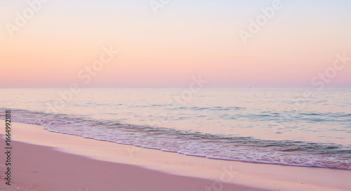 Fototapeta Naklejka Na Ścianę i Meble -  Soft pastel sunset over a calm ocean and sandy beach