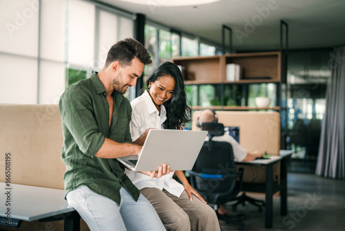 Two happy diverse multiethnic business team people working, talking in corporate office