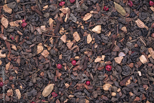 Top view of dried Green tea, Ginger, Cinnamon, Pink peppercorn, Cardamom, clove - Chai Tea