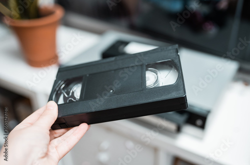 Close up of a hand holding a videotape.