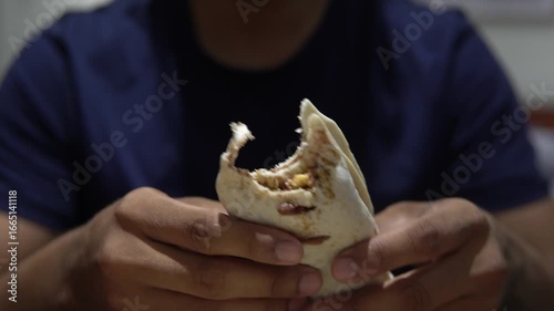 Man eating a burrito at home