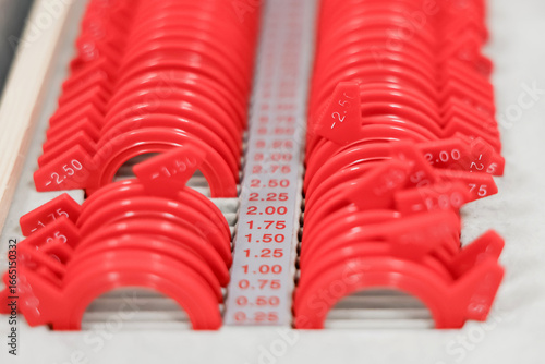 Set of interchangeable trial lenses for refraction tests in optometry. Used with a trial frame to assess visual acuity and correct vision.