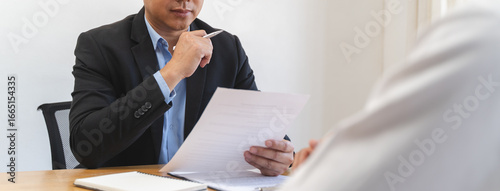 Fotografia Employer or recruiter holding reading a resume during his profile of candidate,