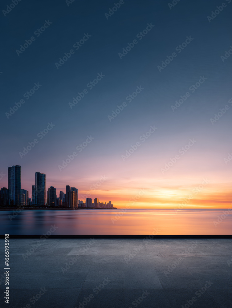 Fototapeta premium City skyline silhouette at sunset over calm water, serene urban landscape with orange sky 