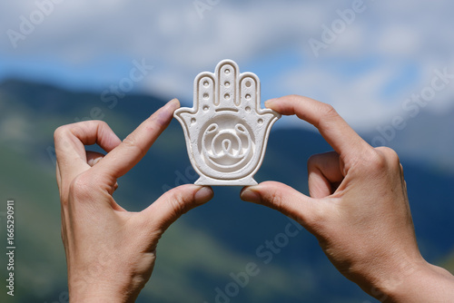 female hands holding yoga symbol
