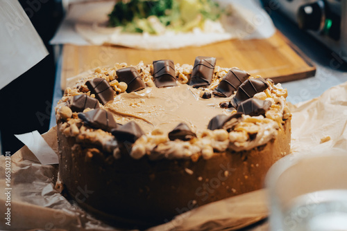 Caramel and nut kinder bueno cheesecake being  placed on the kitchen counter.