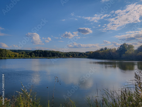 Landscape photo of a tranquil lake in the forest. Rural pond.