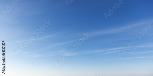 Wallpaper Mural Clear early sky displaying a soothing gradient of blue hues with wispy clouds Torontodigital.ca