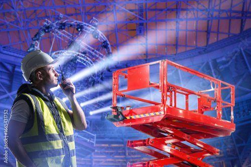 Worker near scissor lift. M...