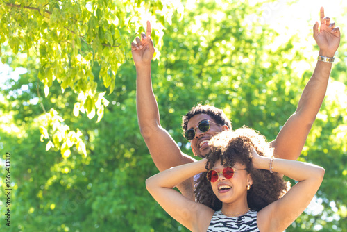 Papier peint young latin couple smiling happily, laughing