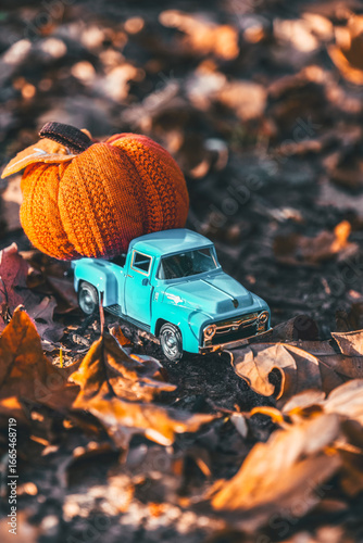 Miniature Truck With Pumpkins on Autumn Leaves.Autumn card with pumpkins and a car.Pumpkin Delivery Concept.
