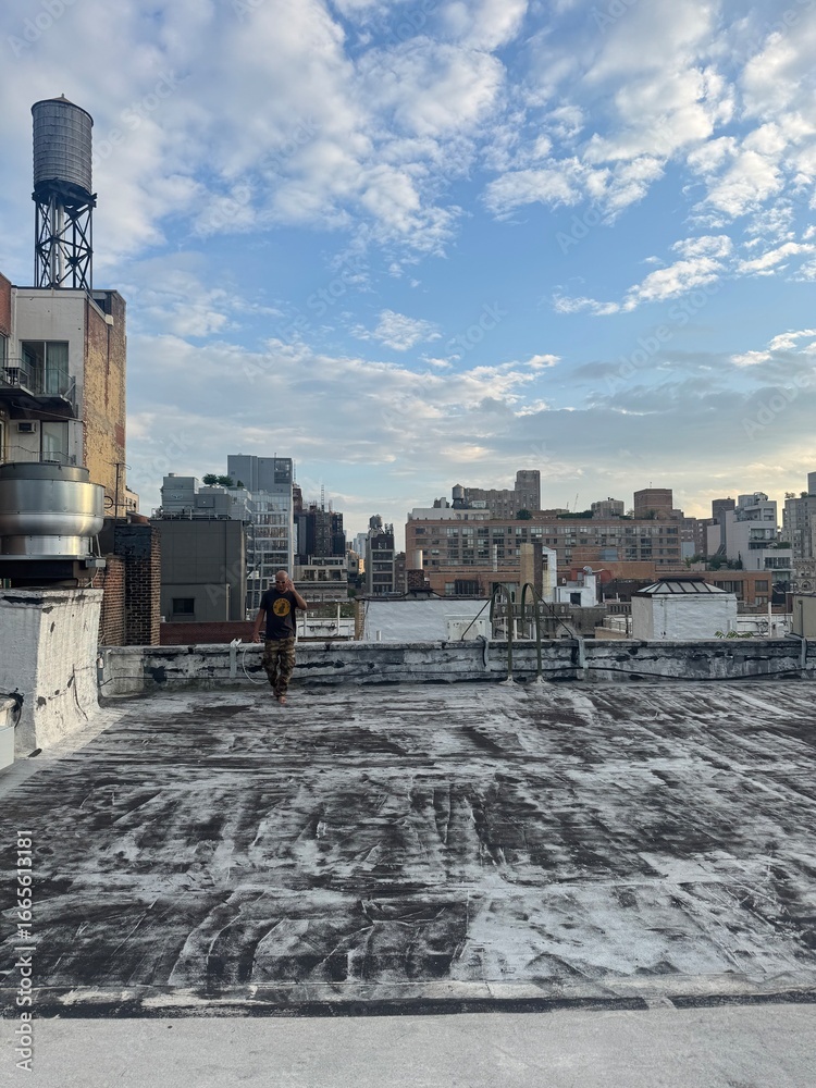Obraz premium Young man on city roof at dusk