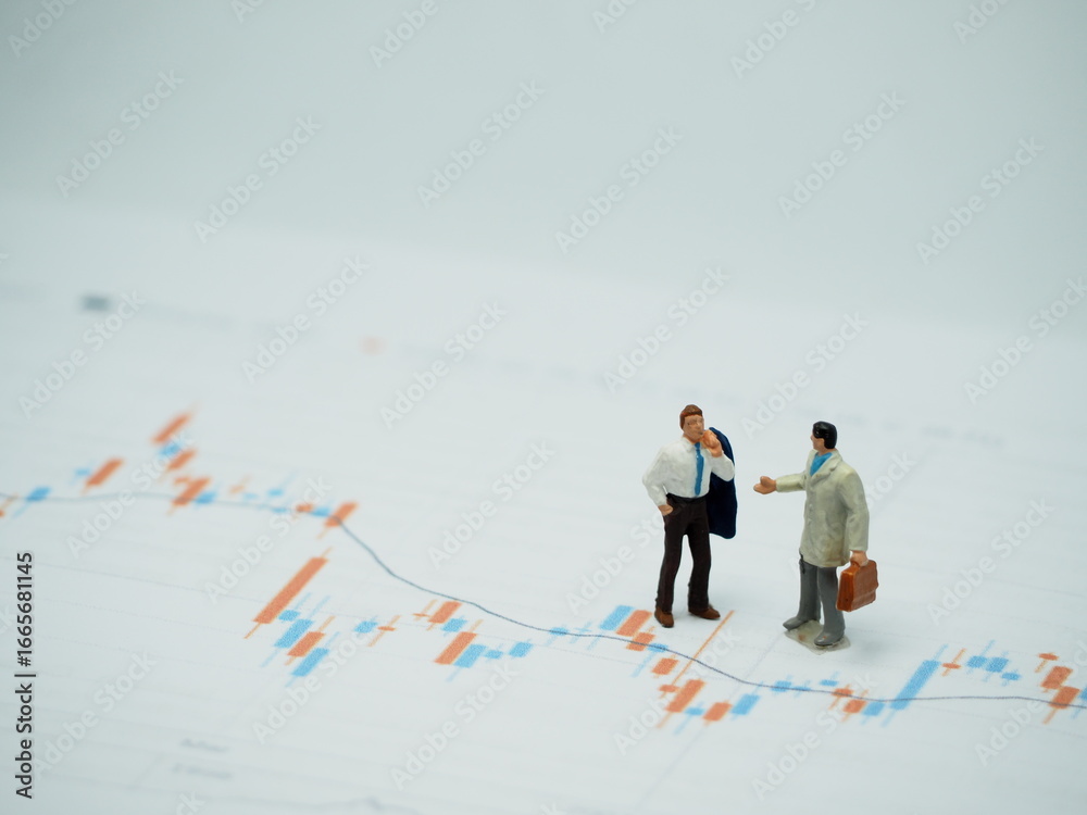 Fototapeta premium Mini toy of action figure at outdoor with blurred background. Miniature photography concept design. Minifigure of businessman character with market graph.