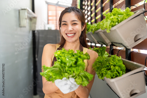 Happy woman growing and take care vegetables in a vertical garden balcony. an urban lifestyle with homegrown food and sustainable living in limited space. Vertical garden concept.