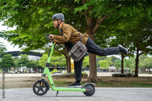 Young Asian man ride scooter EV eco friendly transport. Sustainable save energy lifestyle. Commute and carbon neutral transportation. Asian tourist man put on helmet ride the scooter EV