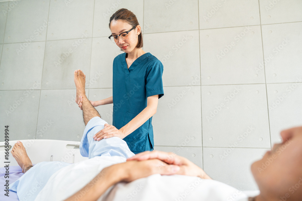 Fototapeta premium Physical therapy. Female Nurse aids young man in recovering from spine injury and providing orthopedic massage Orthopedic healthcare and chiropractor with person for physical therapy rehabilitation