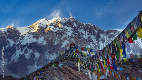 Mount Annapurna peak at sunrise. Buddhist Prayer Flags Against Himalayan Mountain Peaks at Sunrise at Annapurna Base Camp, Nepal