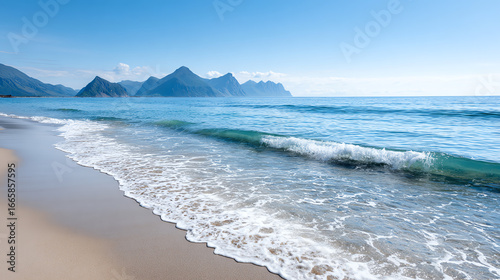 Breathtaking view of a serene beach with gentle waves, mountains in the distance, and a clear blue sky reflecting tranquility and beauty.