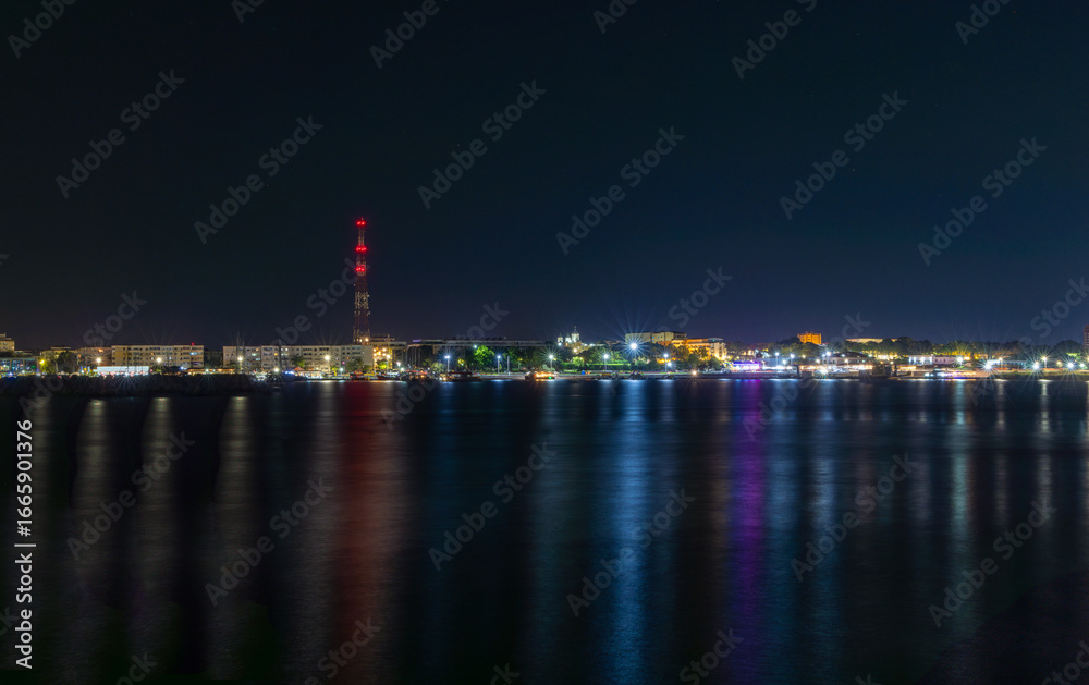 Naklejka premium The city lights reflected in the sea water. Seafront in Mangalia city seen at night