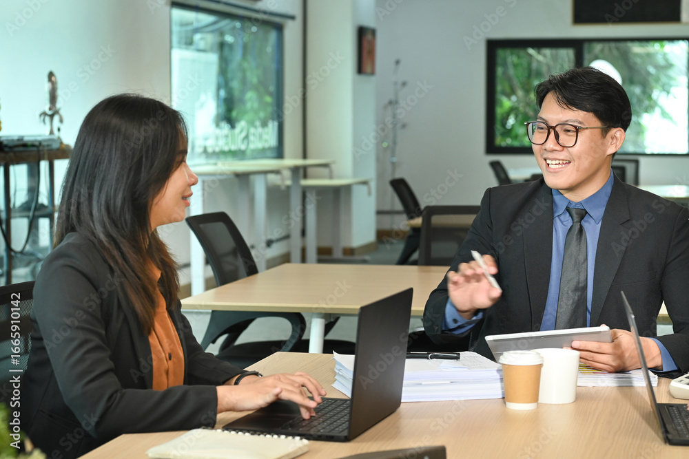 Two happy executives working on laptop discussing financial documents at meeting. Two happy executives working on laptop discussing financial documents at meeting.