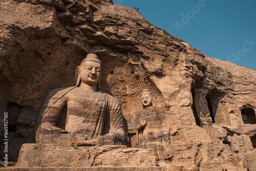 Photography Ancient Yungang Grottoes showcase large Buddha sculptures in tranquil setting