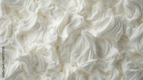 A close-up view of a white, fluffy substance resembling whipped cream or frosting.