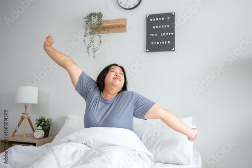 Asian plus-size woman in pajamas wake up in the morning with happiness