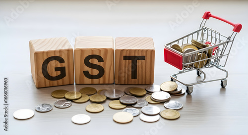 Gst concept with wooden blocks, coins and shopping cart, depicting goods and services tax, an indirect tax used in india on the supply of goods and services