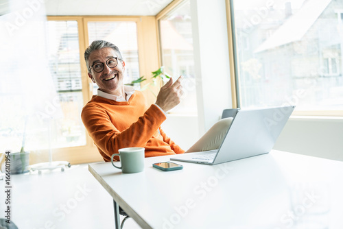 Smiling businessman talking on video call through laptop in office