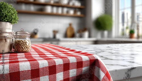 Close-up of a red checkered tablecloth on a marble countertop, in a bright kitchen