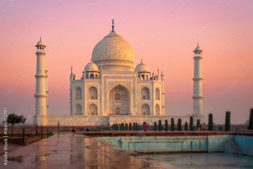 Fototapeta premium Serene Sunrise at the Taj Mahal: Iconic Indian Landmark, Soft Pink Hues, Tranquil Atmosphere, Architectural Detail.
