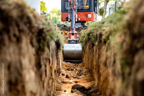 Tableau sur toile Mini excavator bucket in a trench at a construction site