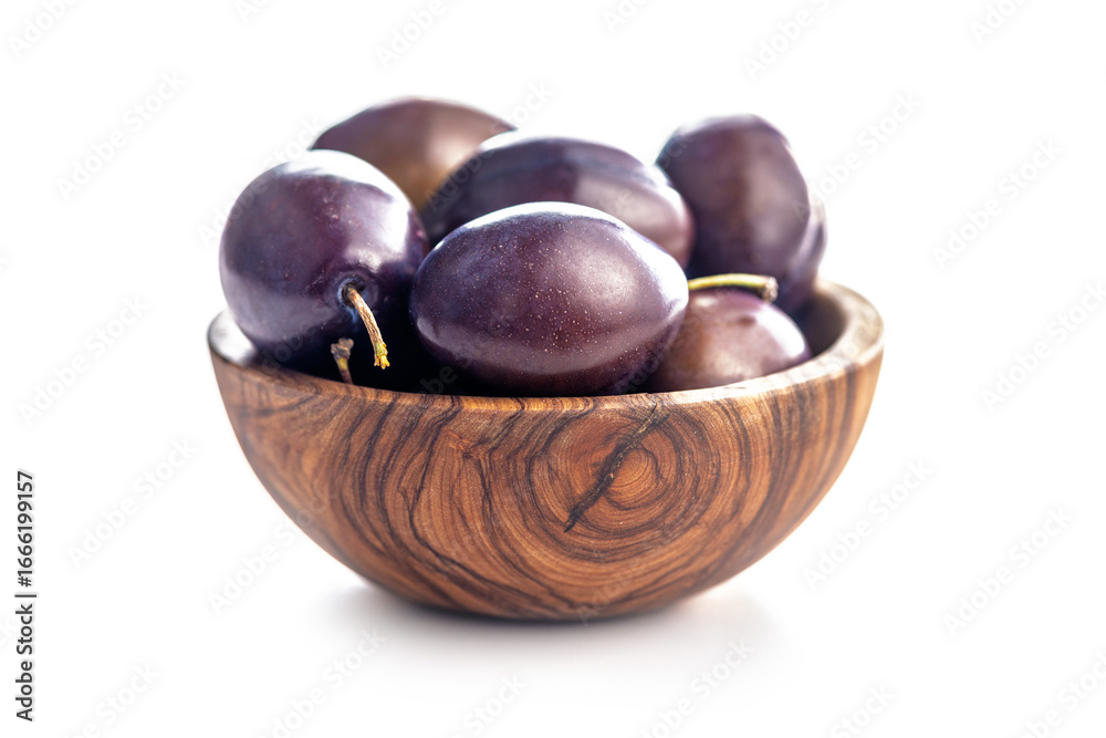 Obraz premium Ripe plums in bowl isolated on white background.